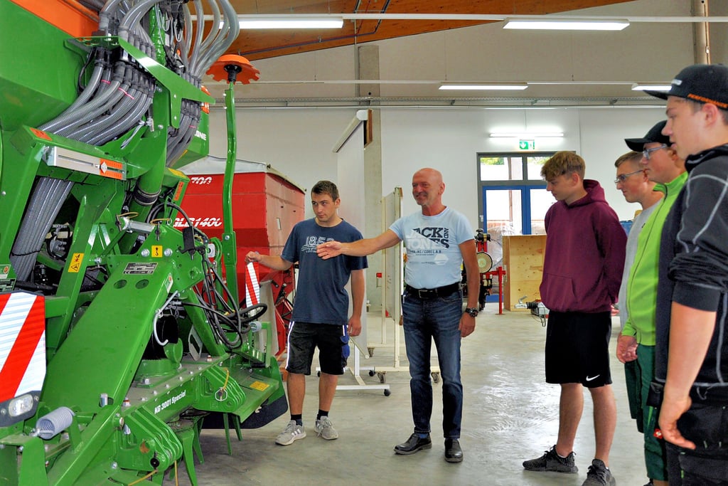 Azubis des dritten Lehrjahres mit Ausbilder Rüdiger Albrecht, der die Funktion eines pneumatischen Schleppers erklärt.