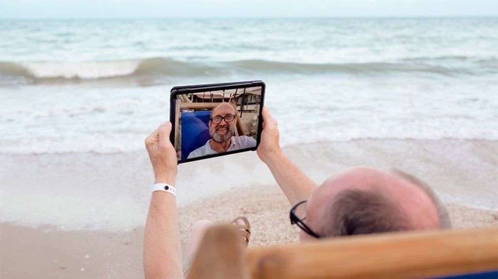 Senior mit Tablet am Strand.