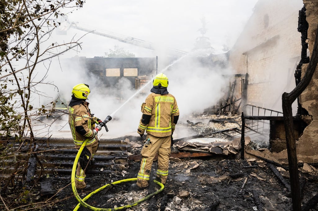 Feuerwehrleute sind bei einem Brand einer leerstehenden Lagerhalle im Einsatz.