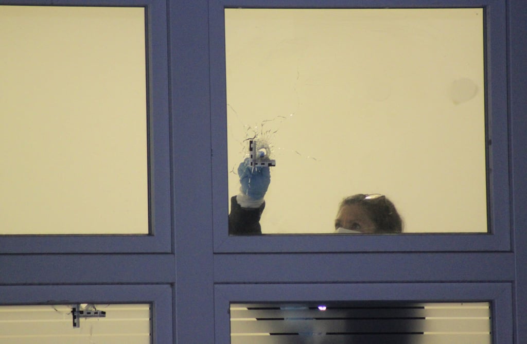 Eine Mitarbeiterin der Spurensicherung vermisst ein Loch in einem Fenster.