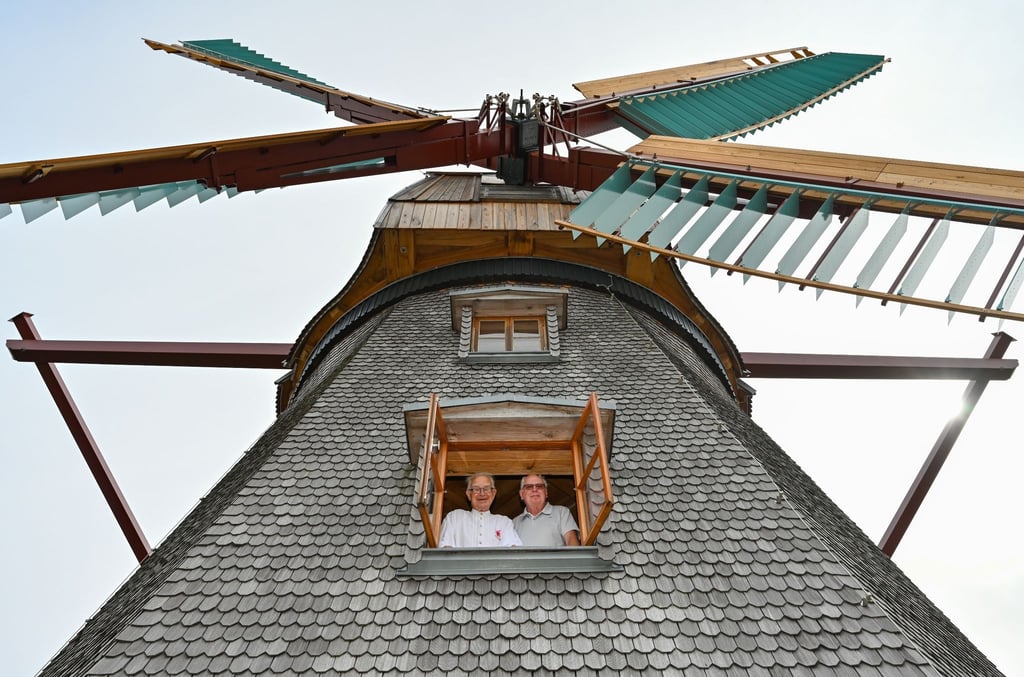 Horst Fichtmüller (l) und Hartmut Hinze schauen aus einem Fenster der Achtkant-Erdholländermühle.