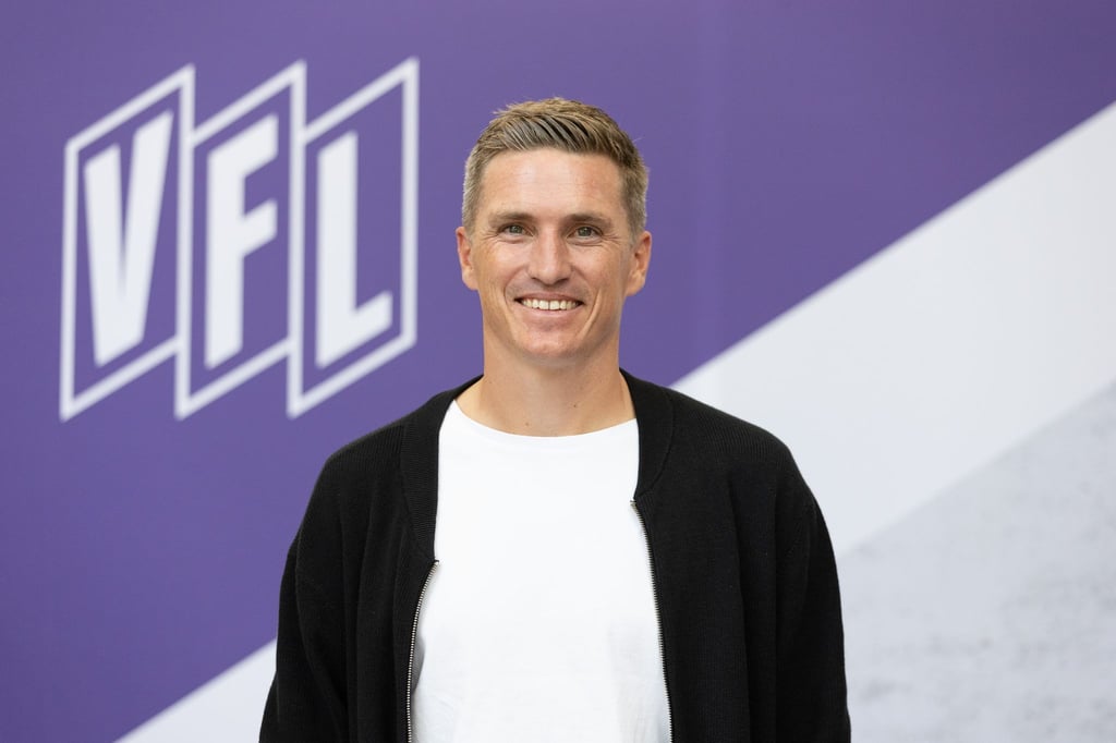 Tobias Schweinsteiger posiert vor einem Vereinslogo im Stadion an der Bremer Brücke.