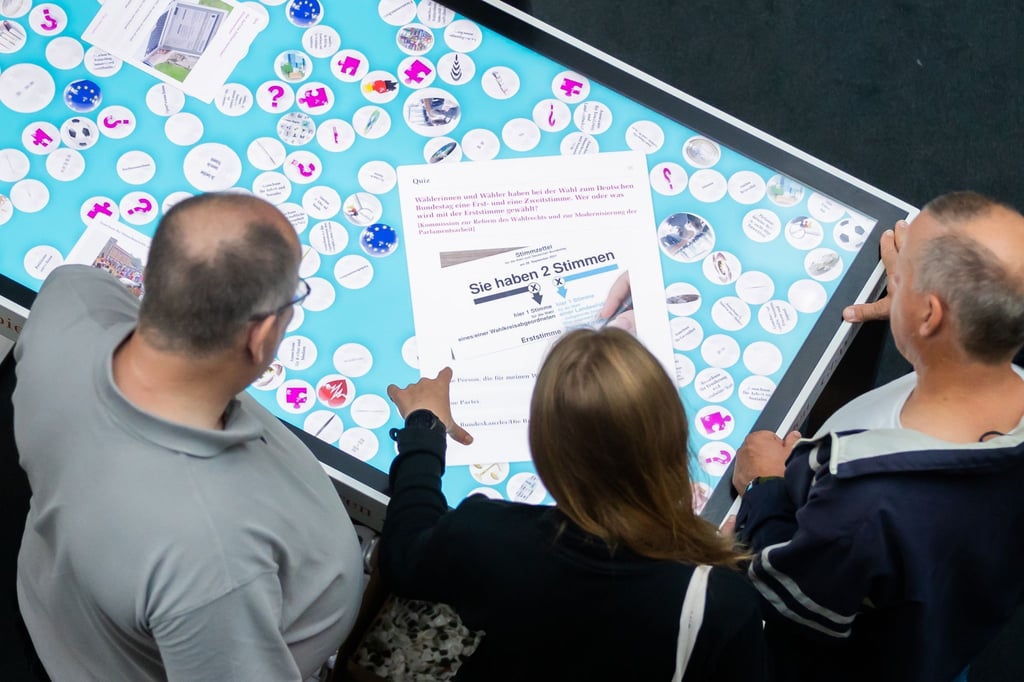 Besucher spielen beim „Tag der Ein- und Ausblicke“ im Deutschen Bundestag ein Quiz auf einem Touch-Screen.