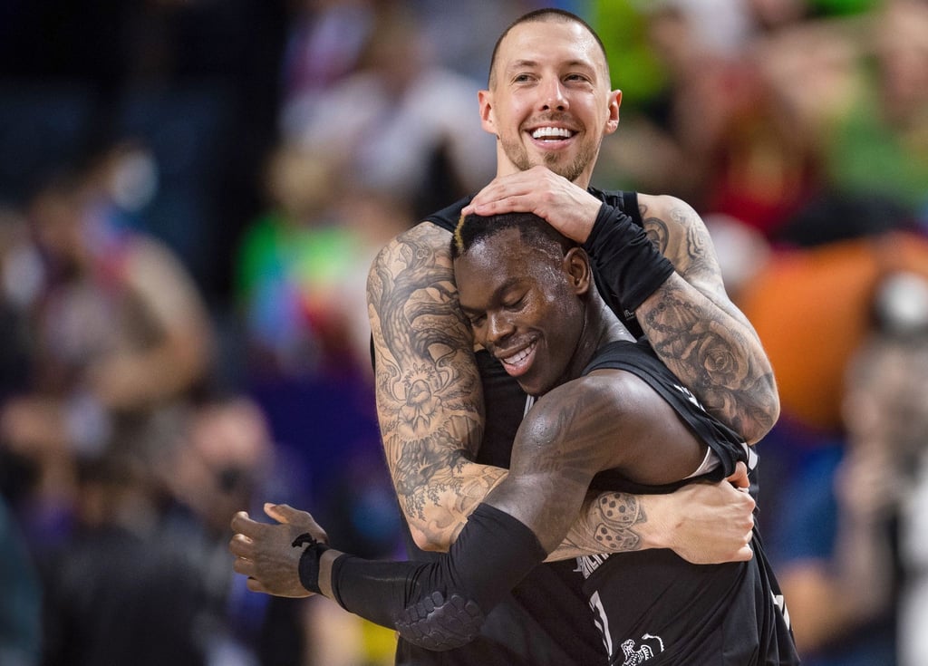 Deutschlands Dennis Schröder (r) und Daniel Theis liegen sich nach der Partie in den Armen.