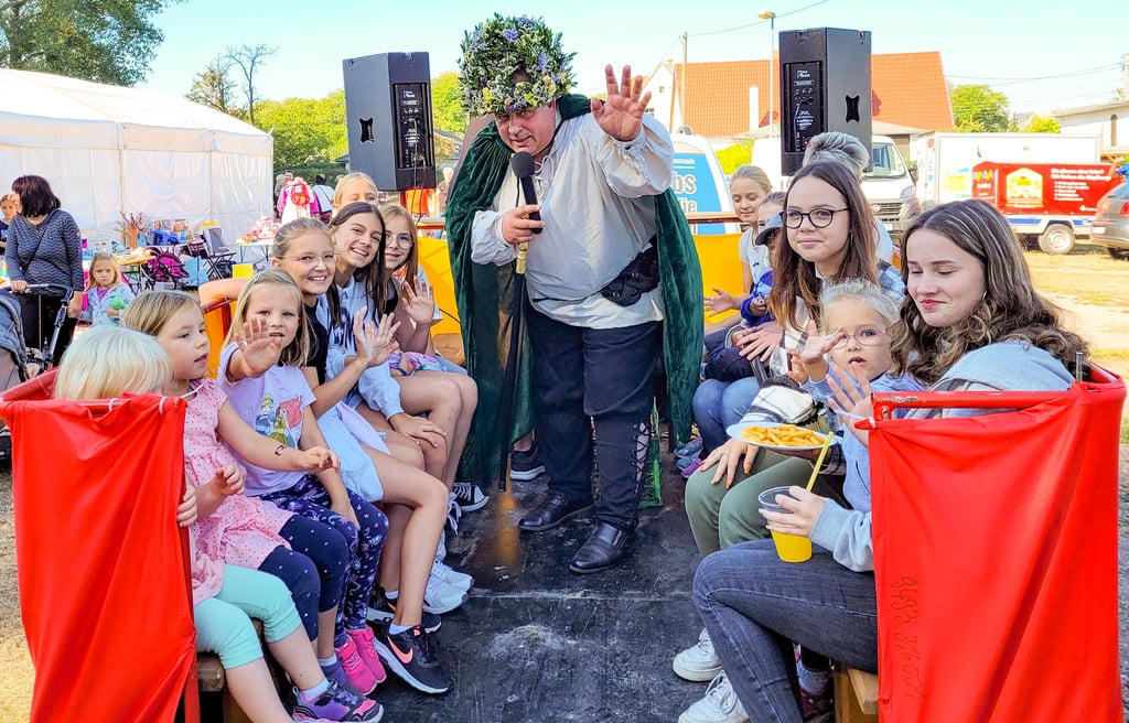 Zwiebelbaron Heiko Strube heizt den Kindern ein, bevor die Dorfrundfahrt beginnt.