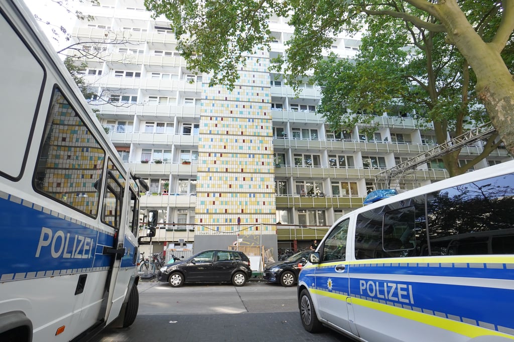 Einsatzfahrzeuge der Polizei stehen vor einem Wohnhaus in der Löwenberger Straße in Berlin-Lichtenberg. Mit einer Axt hat ein Mann in Berlin-Lichtenberg eine Frau getötet. Der Täter wurde von Polizisten erschossen, die ihn stoppen wollten.