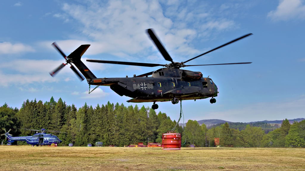 Der 19 Tonnen schwere Bundeswehrhubschrauber vom Typ CH 53 hebt mitsamt Löschwasserbehälter  ab Richtung Okertalsperre. 