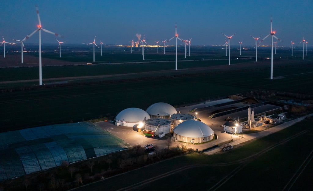 Windräder drehen sich hinter einer Biogasanlage in Bad Lauchstädt im Saalekreis. Die Energiegewinnung aus Wind und Abfall wird auch in der Region vorangetrieben. Nach Bernburg soll Colbitz Standort einer Bioabfallvergärungsanlage werden. Magdeburg steigt aus dem Rennen um die Biogasproduktion aus und exportiert seinen Bioabfall weiter ins Umland.
