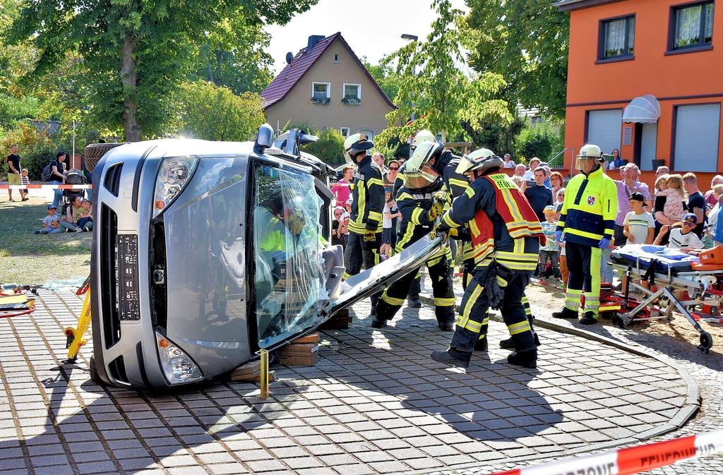 Bei einer Schauvorführung bergen die Feuerwehrleute eine eingeklemmte Person (Übungspuppe) aus einem Unfallwagen.