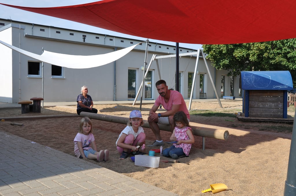 Elisabeth, Emma und Lucy (vorne von links) freuen sich in der Magdeburger Kita „Spielinsel“ über ein schattiges Plätzchen im Sandkasten. Kita-Leiter Sebastian Targé hat zusätzliche Sonnensegel erfolgreich beim Jugendamt eingefordert und ist sehr erleichtert. Teile der Außenanlage seien ohne den zusätzlichen Schutz im Sommer nicht mehr nutzbar gewesen.