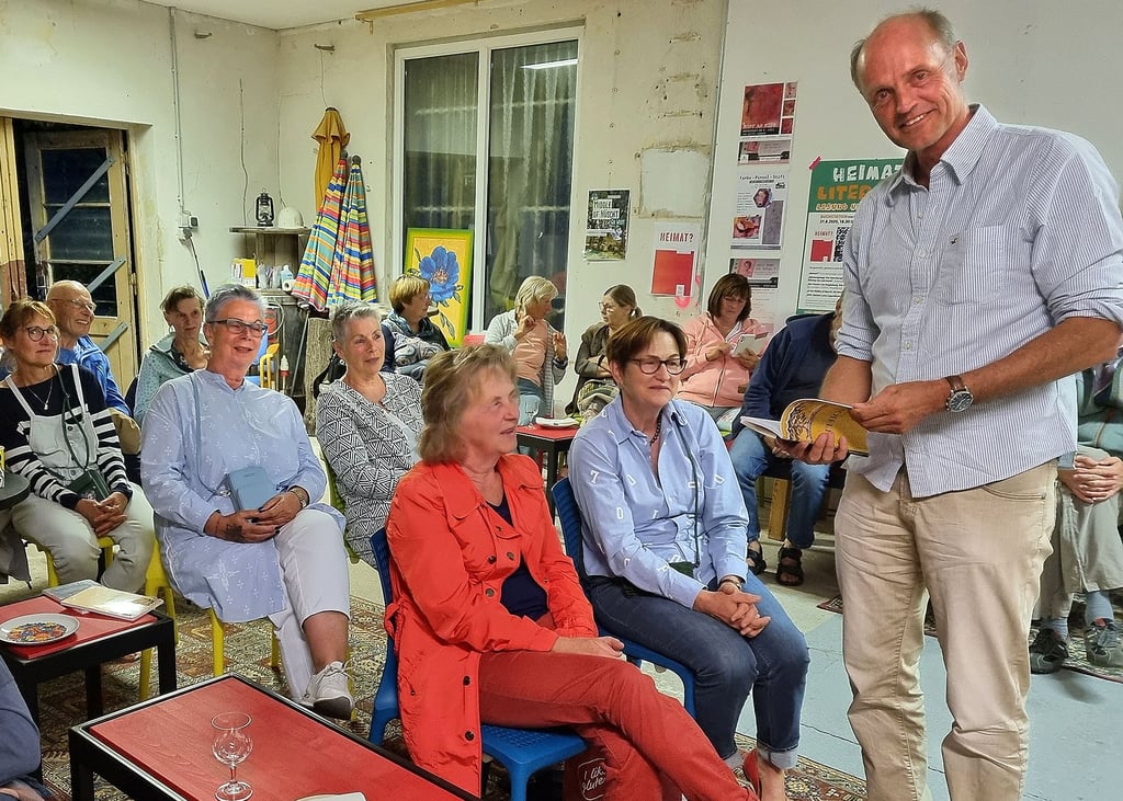 Am Dienstagabend las Bernd Bierbaum (stehend) in der Halle auf dem Künstlerhof an der Buchstation unter dem Motto „Vom Ende der Welt nach Havelberg“. Er stellte dabei auch zwei Büchlein vor.