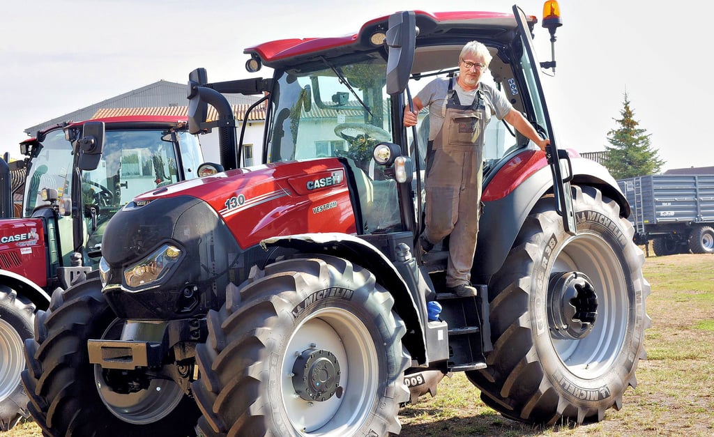 Mechaniker Maik Rinkleib an einem der Traktoren, die bei der WHJ Landtechnik in Wolferstedt für den Verkauf bereitstehen.