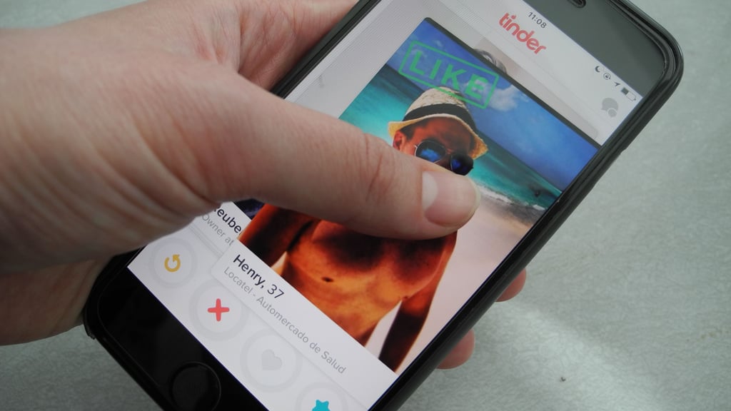 Ein Nutzer hält ein Smartphone, auf dem die App Tinder läuft, in der Hand. Die Dating-App startete am 12. September vor zehn Jahren.