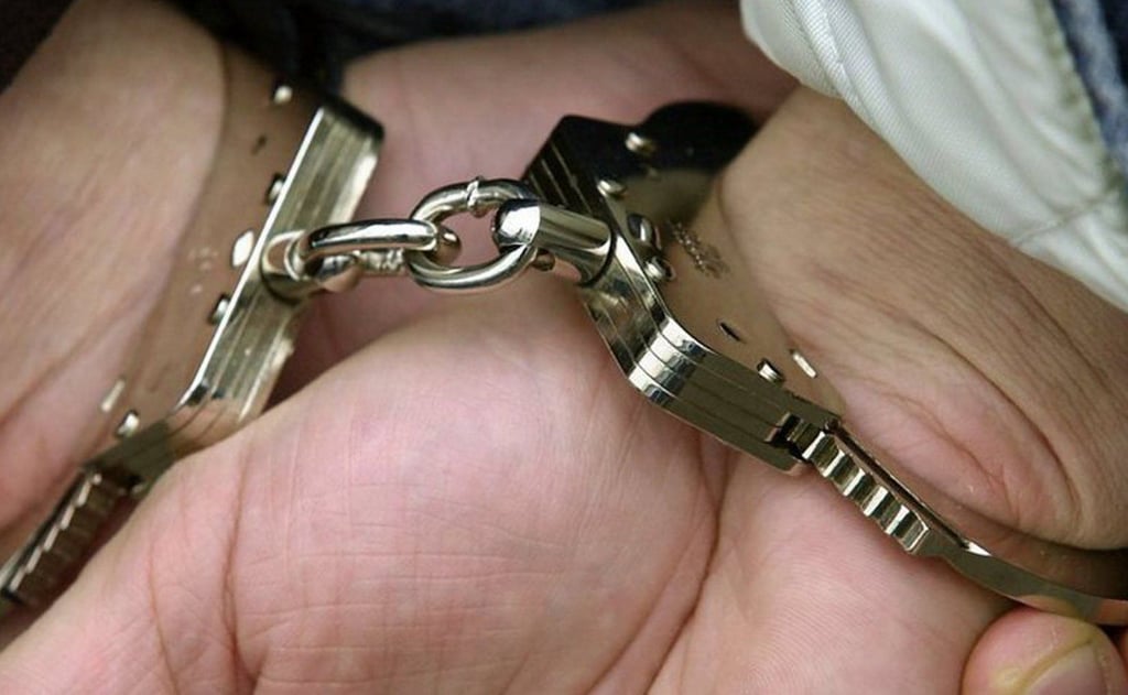 Ein Verdächtiger wird in Handschellen abgeführt.