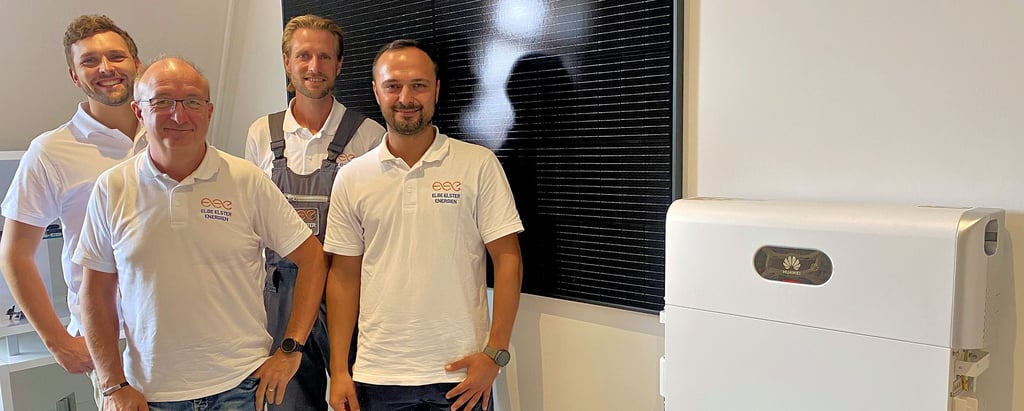 Das Leitungsteam der neuen Firma „Elbe Elster Energien“ vor einer Präsentationswand mit dem, was sie zu einem ihrer wichtigsten unternehmerischen Standbeine machen wollen, einer Fotovoltaikanlage mit Speicher: Arne Ungruh, Arno Vogel, Marcus Gärtner und Candy Feil (von links).