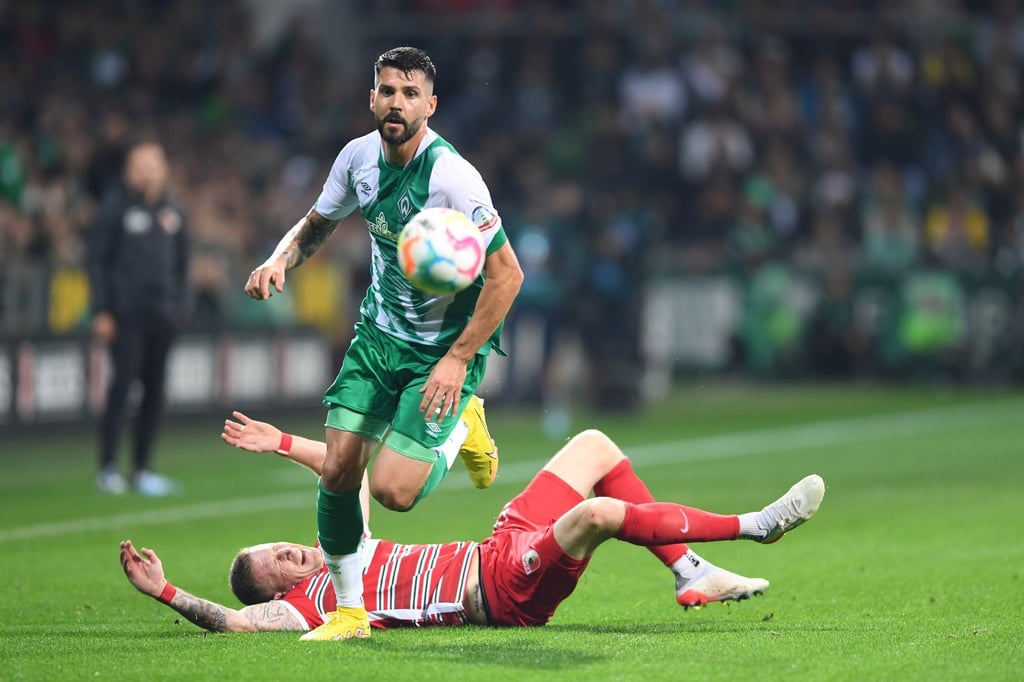 Werders Anthony Jung hat sich gegen den Augsburger Andre Hahn (am Boden) im Kampf um den Ball durchgesetzt.