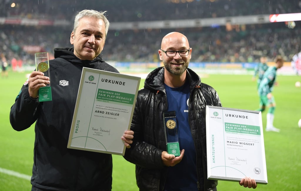 Werders Stadionsprecher Arndt Zeigler (l) und Mario Wiggert mit der Fair-Play-Medaille.