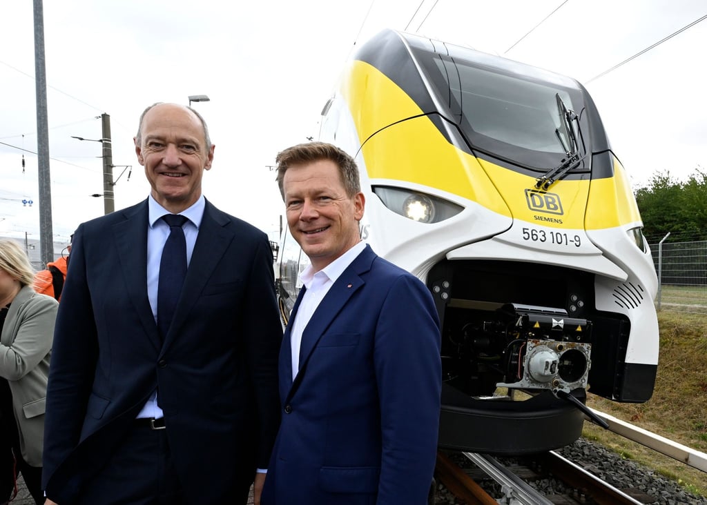 Roland Busch (l), Vorstandsvorsitzender von Siemens, und Richard Lutz, Vorstandsvorsitzender der Deutschen Bahn, stehen vor einem neuartigen Wasserstoffzug.