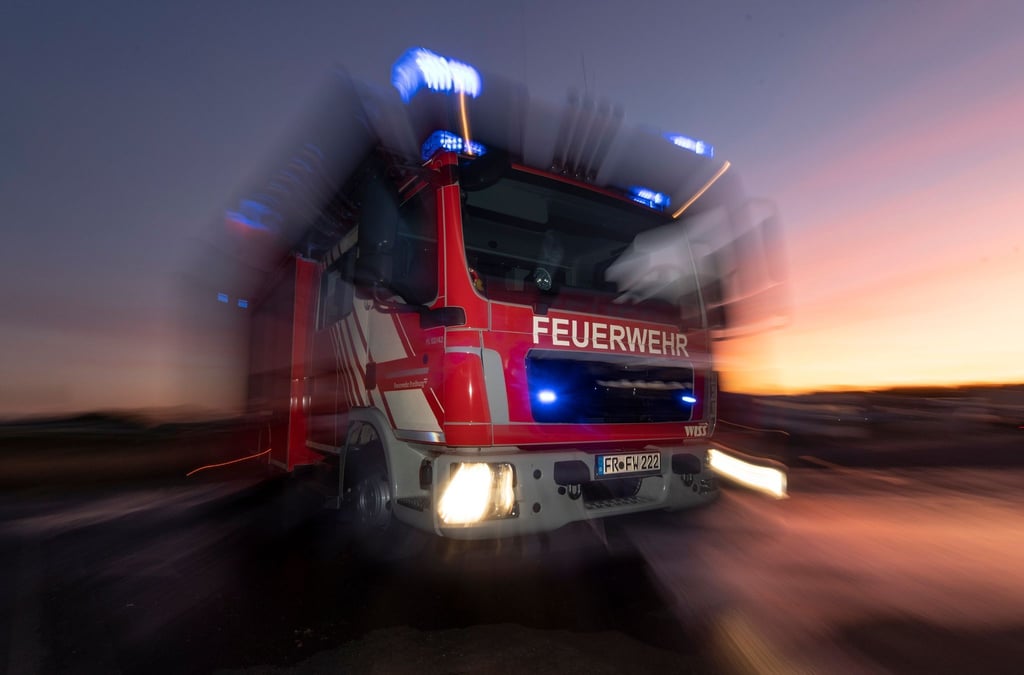 Ein Feuerwehrfahrzeug mit eingeschaltetem Blaulicht.