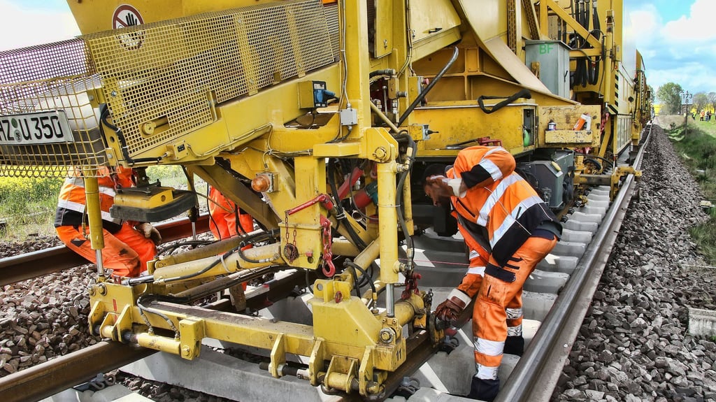 Arbeiter verlegen Betonschwellen. Ein bestimmter Bautyp steht im Verdacht, das tödliche Zugunglück Anfang Juni in Bayern mit verursacht zu haben. Nun werden die Bauteile ausgetauscht - jedes dritte liegt in Ostdeutschland.