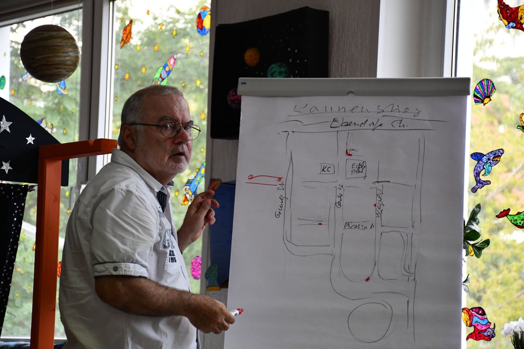 Lutz Fiedler, Sprecher der AG Gemeinwesenarbeit (GWA) Magdeburg-Kannenstieg, zeigt auf einer Karte des Stadtteils mögliche Standorte für neue Bänke.