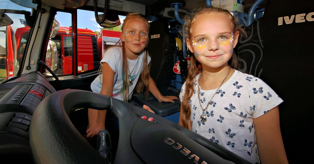 Lena (r.) und Ida von der Kinderfeuerwehr Deetz sitzen vorn im Hilfeleistungslöschgruppenfahrzeug.