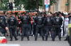 Leipzig: Polizisten stehen an einer Straße im Süden der Stadt hinter einer Polizeiabsperrung, an der sich Aktivisten (hinten) versammelt haben, um gegen eine Abschiebung zu protestieren. Eine geplante Abschiebung hat in der Leipziger Südvorstadt zu einem größeren Polizeieinsatz geführt.