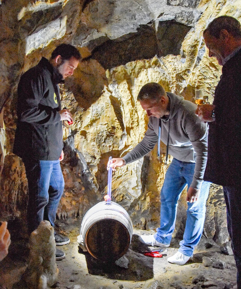 Hadrian Bromma, Geschäftsführer der Bavery GmbH, nimmt eine Probe aus einem Rumfass in der Baumannshöhle. Markus Mende (links) und Thomas Schult (rechts) assistieren.