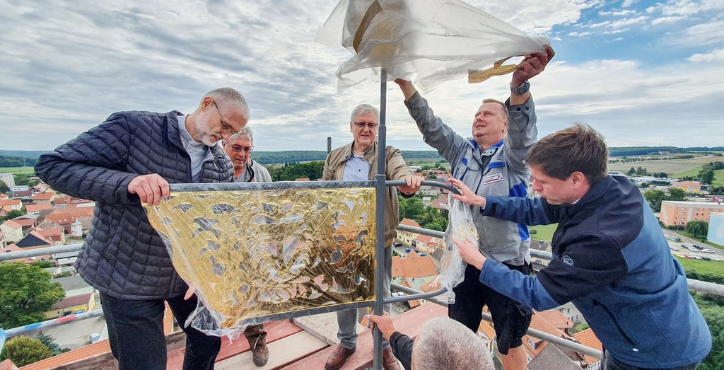 Die restaurierte Wetterfahne der Kirche St. Marien wird ausgepackt. Seit Dienstag weht sie wieder hoch über den Dächern der Stadt.