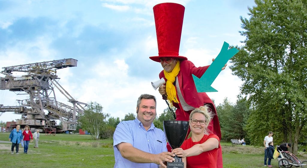 Bürgermeister Enrico Schilling und die Geschäftsführerin der Ferropolis gGmbH Janine Scharf präsentieren den Pokal für den „Schnellsten Arsch“.