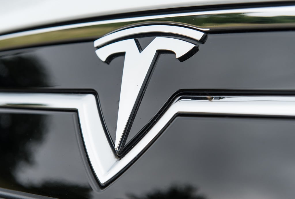 Das Logo von Tesla ist auf einem Auto zu sehen.
