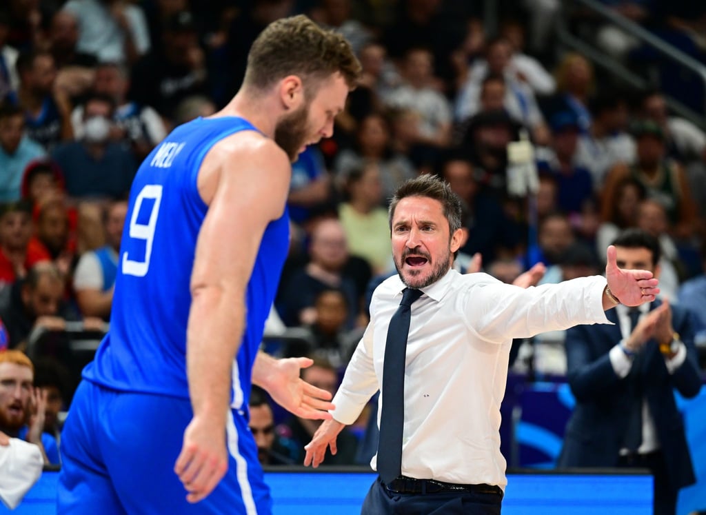 Italiens Trainer Gianmarco Pozzecco (r) klatscht mit seinem Spieler Nicolo Melli (l) ab.