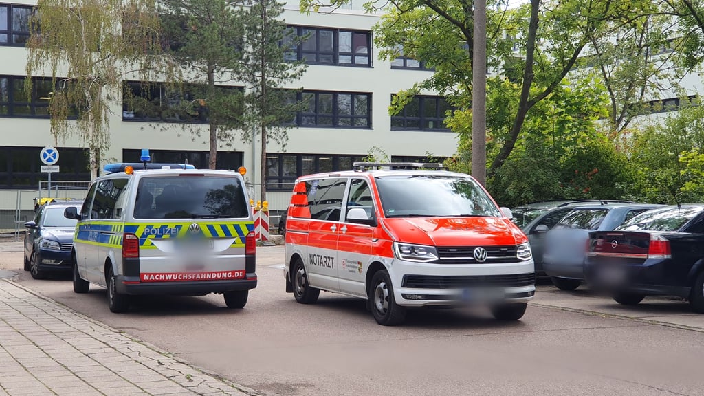 Polizei und Notarzt vor der Berufsschule in der Harzgeroder Straße in Halle-Neustadt.
