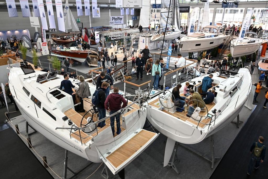 Besucher schauen sich in der Messehalle A3 verschiedenen Segelboote an.