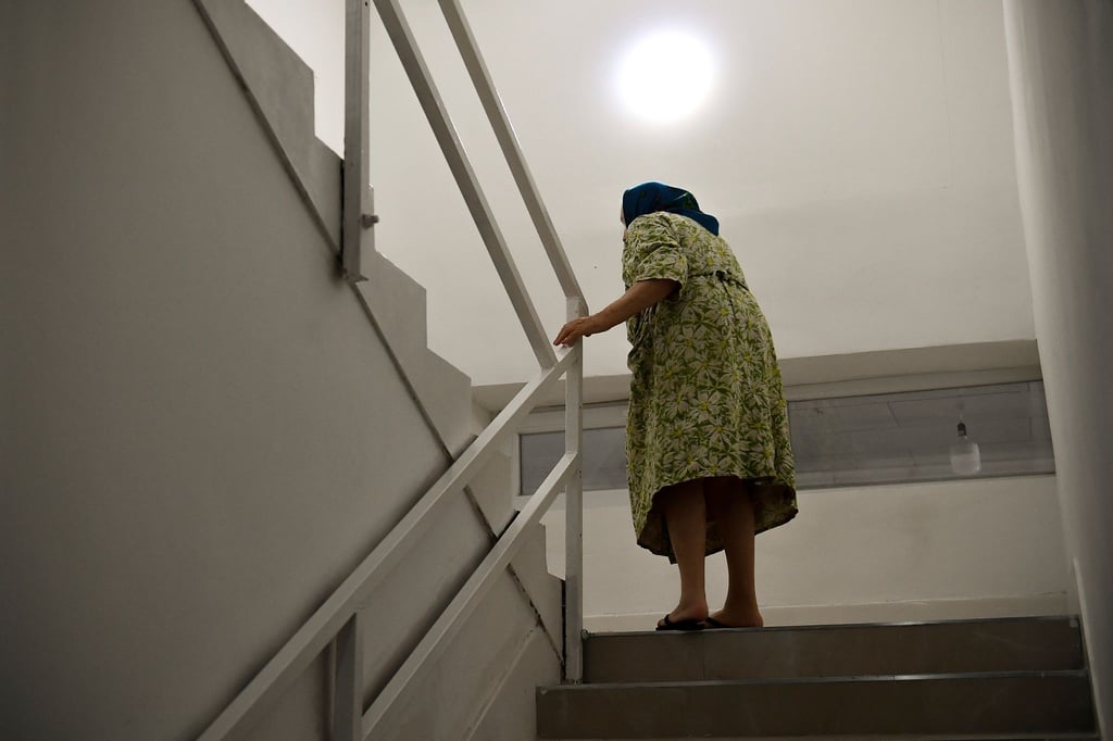 Eine Frau geht in einem Wohnheim eine Treppe hoch.
