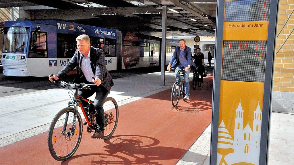 Der Baubeigeordnete Jörg Rehbaum und Magdeburgs ADFC-Vorsitzender Norman Dreimann sind die ersten, die auf dem neuen Radweg die neue Fahrrad-Zählstelle passieren.