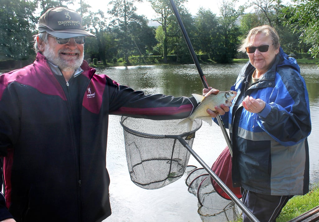 Heike Wanowski (rechts), Sprecherin des Landesverbandes für Angler mit Handicap, und ihr Unterstützer Michael Harbauer, freuen sich über ihren Fang. Die junge Brasse muss natürlich für ein Erinnerungsfoto präsentiert werden und wurde hinterher in den Teich zurückgesetzt.