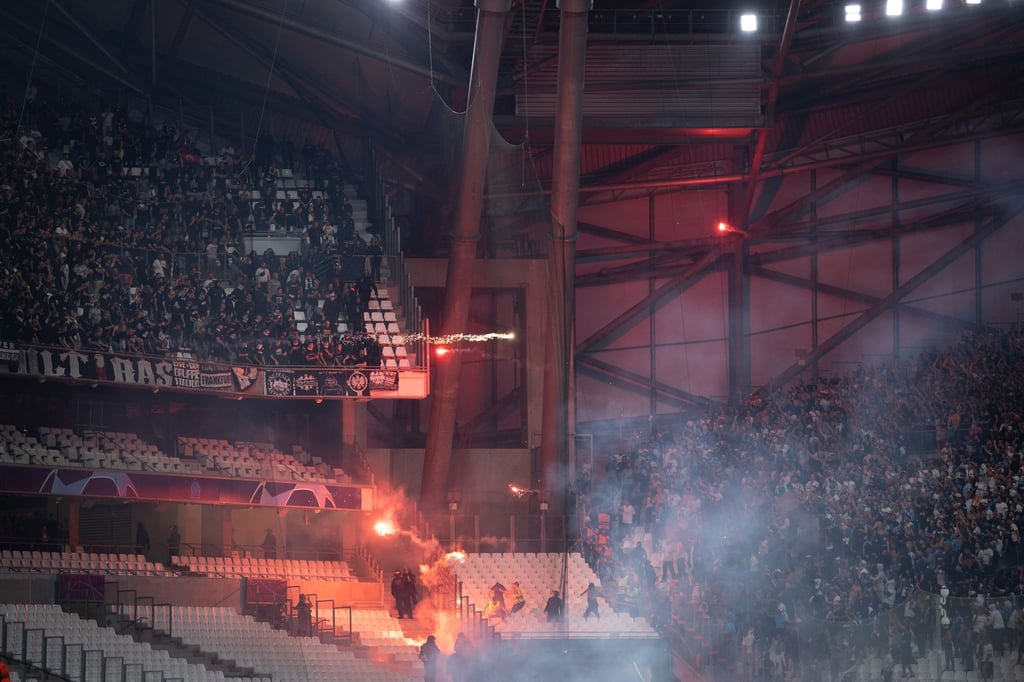 die Blöcke der Ultras der Eintracht (l) und von Marseille beschießen sich mit Feuerwerk.