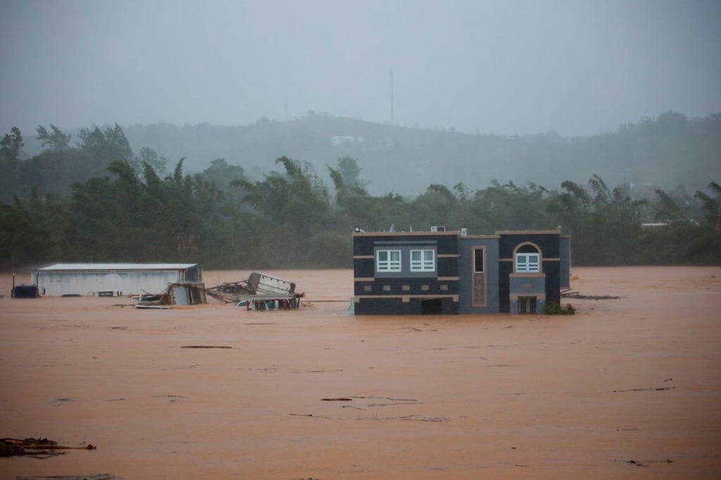 Drei Menschen warten in einem Haus auf Rettung vor den Überschwemmungen, die Hurrikan „Fiona“ in Puerto Rico verursacht hat.