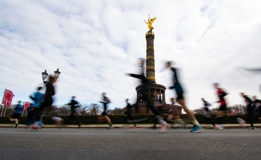 Teilnehmer am Berliner Halbmarathon laufen an der Siegessäule vorbei.
