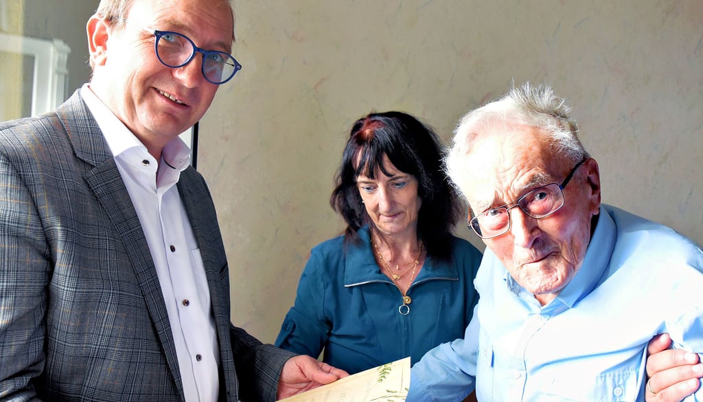 Landrat Markus Bauer gratuliert Franz Krause, dem ältesten Feuerwehrmann Sachsen-Anhalts, zum 105. Geburtstag. Im Hintergrund Tochter Martina.