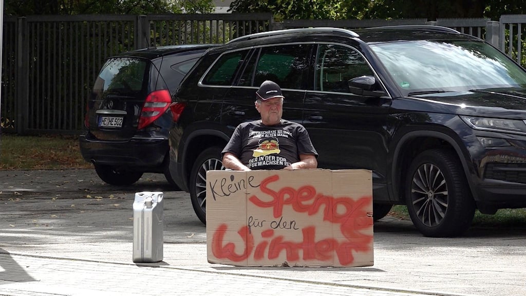 Holger Thude demonstriert mit seinem selbstgemalten Plakat an der B245a in Harbke gegen die hohen Gaspreise.