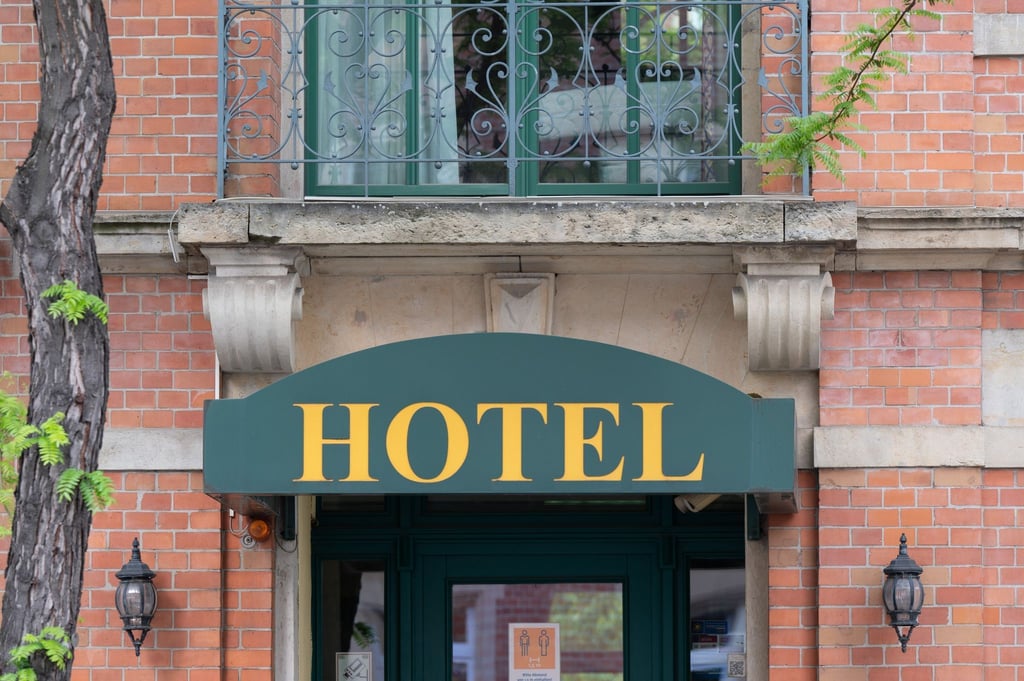 Ein Schild mit der Aufschrift „Hotel“ hängt an einem Hauseingang.