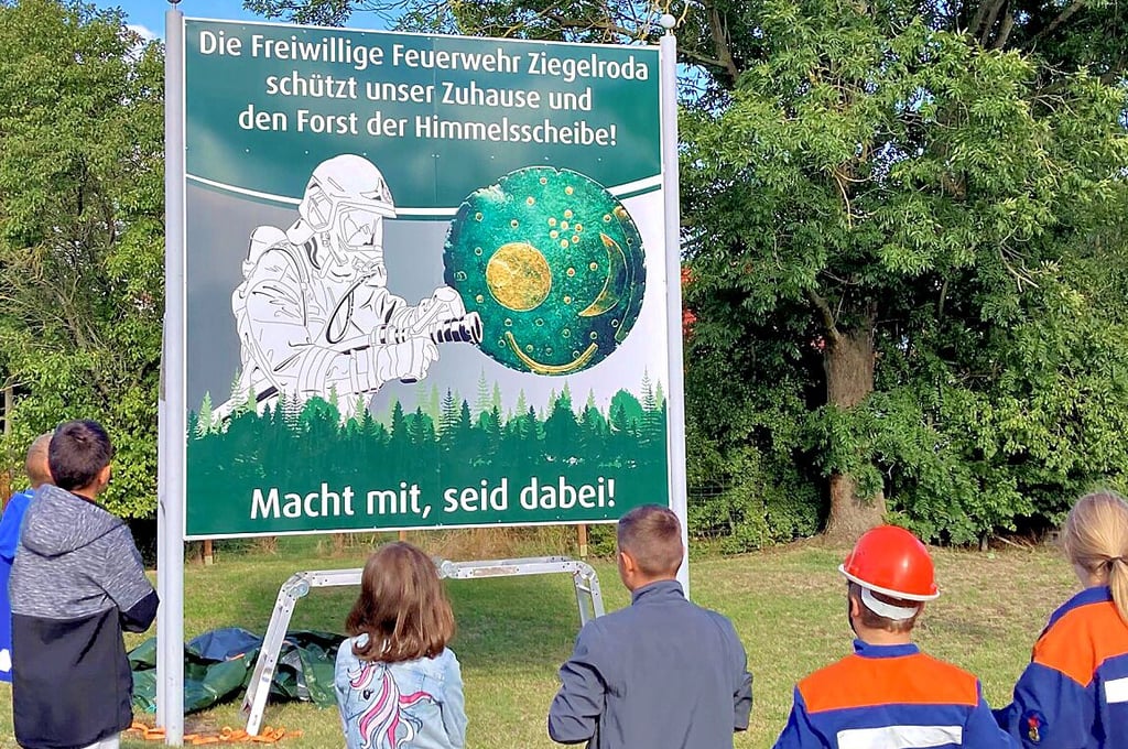 Das neue Schild verbindet Feuerwehr und Himmelsscheibe.