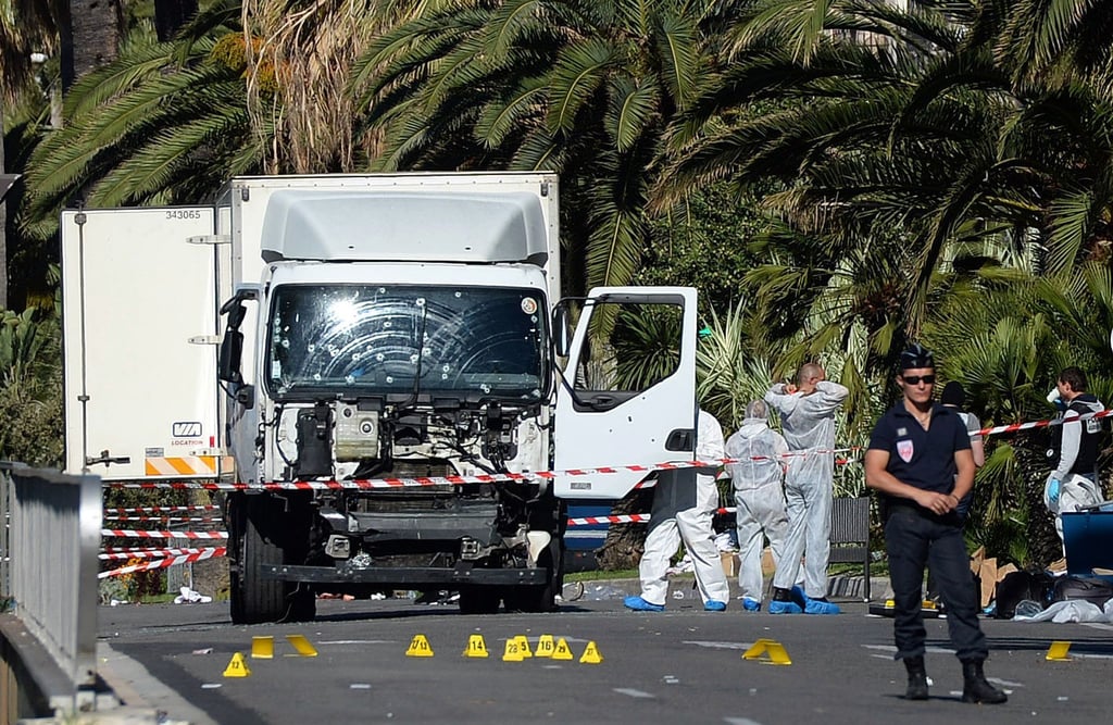 Polizisten stehen um den Lastwagen, mit dem der Attentäter in Nizza in eine Menschenmenge an der Strandpromenade gerast war.