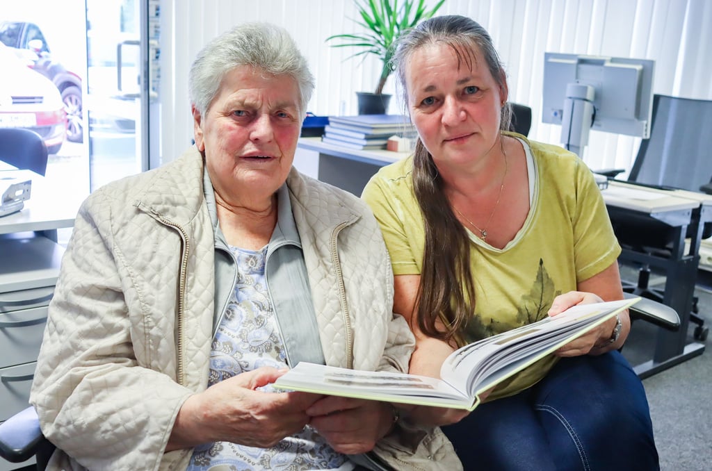 Thea Thoms (links) und Kerstin Schulze blättern in dem Buch, das die lange Geschichte des Reit- und Fahrvereins Klötze beleuchtet. Auf einigen Bildern ist Thea Thoms abgebildet, die 1953 in den Verein eintrat, damals als einziges Mädchen.