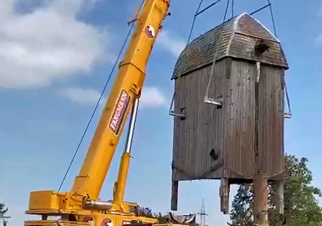 Mit Hilfe eines Krans wird die Windmühle vom maroden Bock gehoben und in einen Stahlrahmen gestellt. Erst wenn die Standfestigkeit gesichert ist, kommt die „alte Dame“ wieder auf ihren Platz.