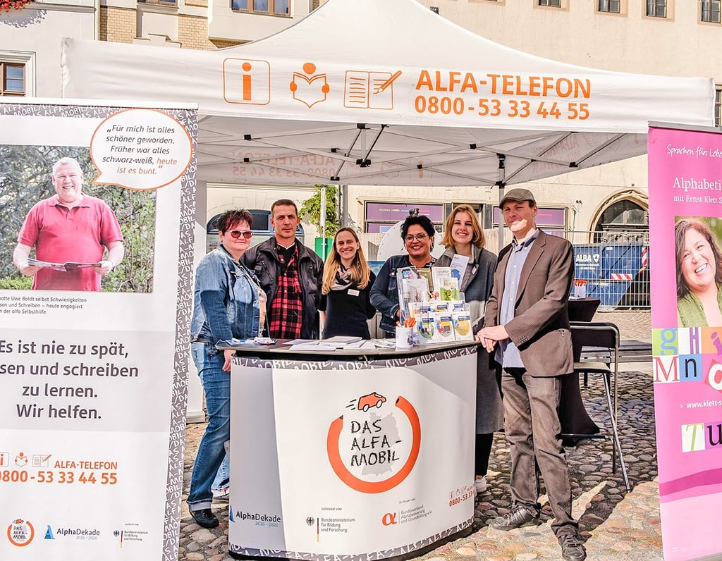 Das Team von Alfa-Mobil und Kreisvolkshochschule Wittenberg informiert auf dem Marktplatz über funktionalen Analphabetismus.