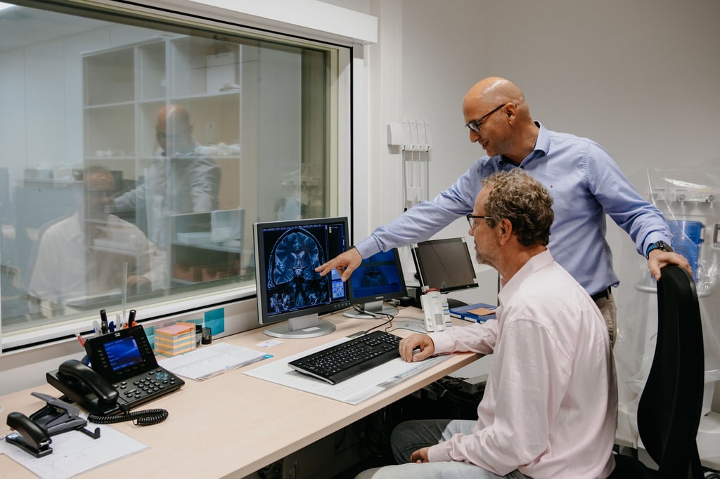 Dr. Emrah Düzel (stehend), Leiter des Instituts für kognitive Neurologie am Uniklinikum Magdeburg, und Dr. Michael R. Kreutz vom Leibnitz-Institut für Neurobiologie Magdeburg betrachten per Hirnscanner (MR-Pet) das Gehirn eines Alzheimer-Patienten.