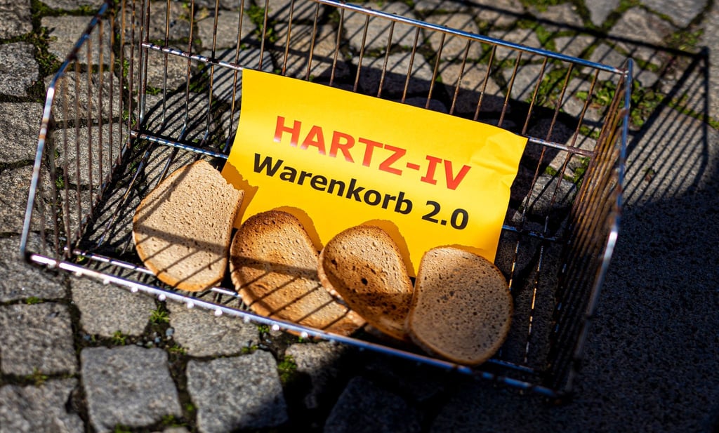 Der Schriftzug „Hartz-IV Warenkorb 2.0“ ist auf einem Zettel zu lesen.
